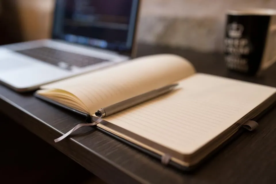 Open notebook in front of a laptop, for brand identity and design work