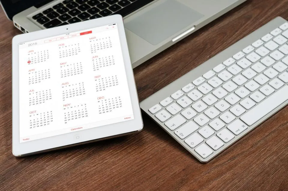 Tablet showing a calendar app beside a keyboard, for custom software and app development