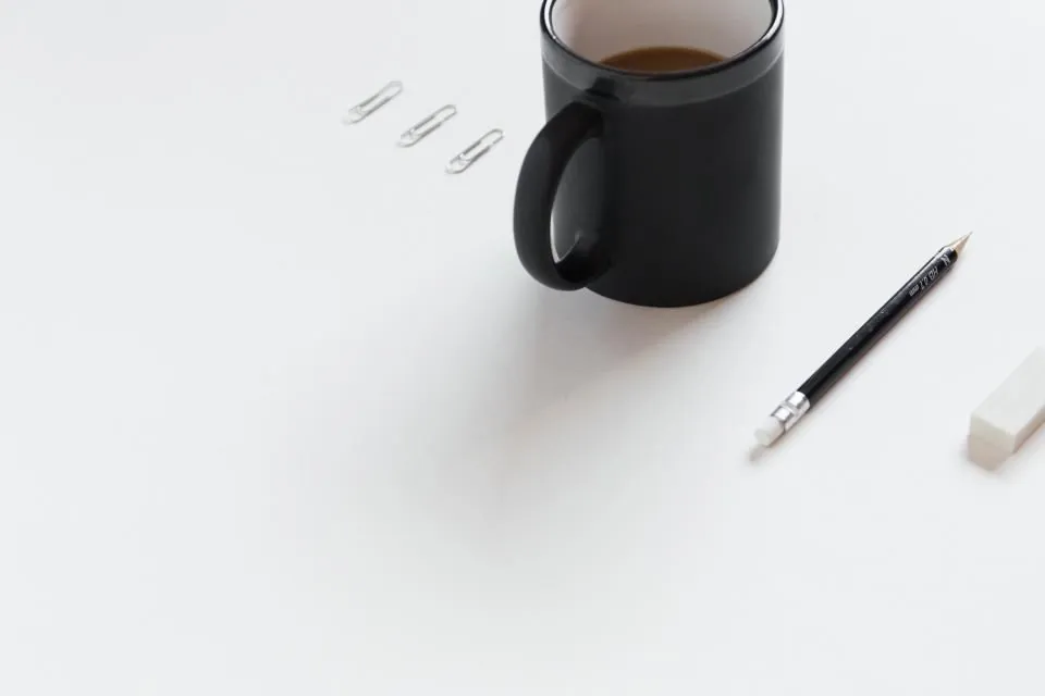 A tidy desk with a mug and a pen: one small team doing the work